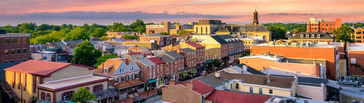West Chester, Pennsylvania at sunset, looking across the rooftops of High Street toward the courthouse clock tower.